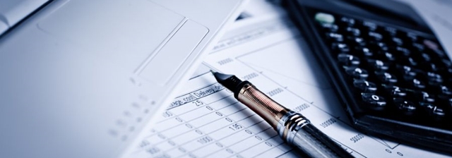 Caneta calculadora e papeis na mesa prontos para fazer a declaração de imposto de renda